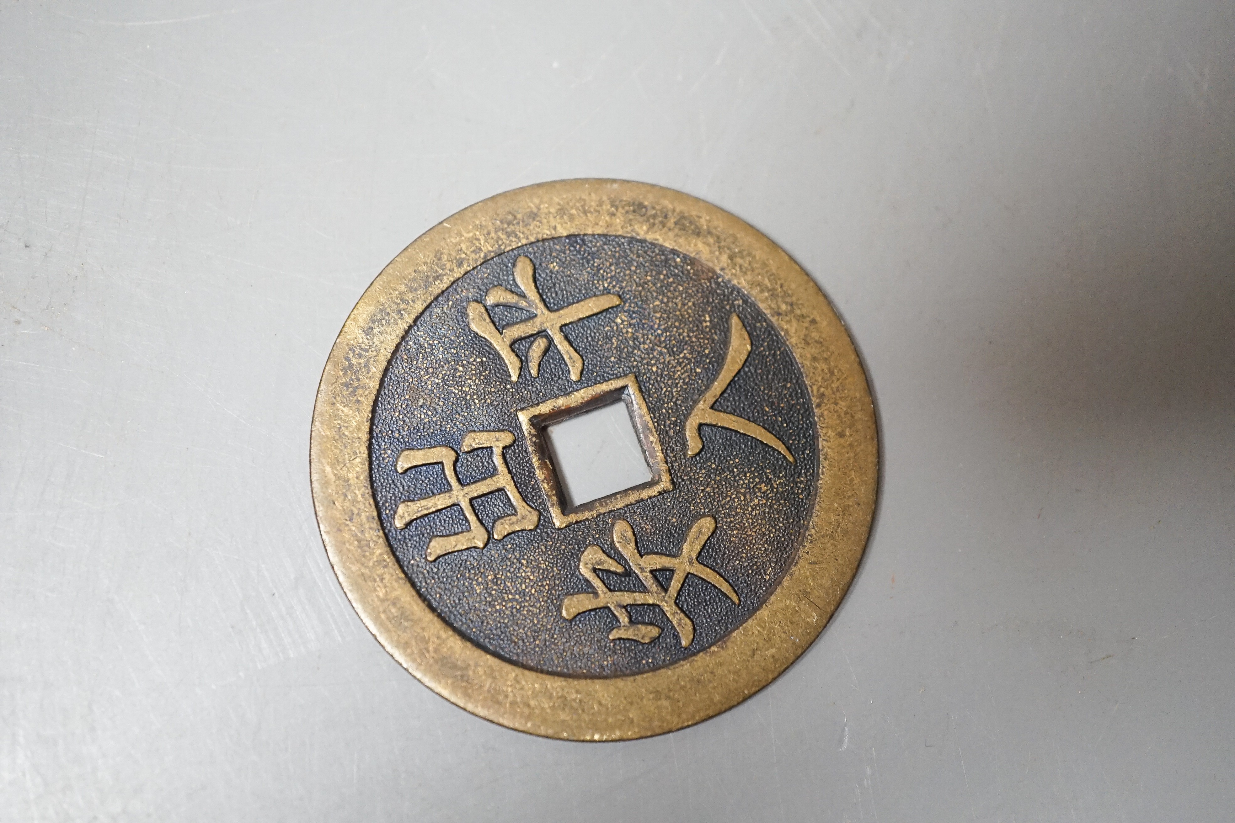 A Chinese soapstone snuff bottle, another snuff bottle, a bamboo page turner, 40cm and a brass amulet